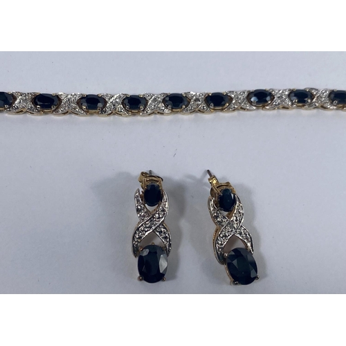 523 - A silver gilt suite comprising necklace, bracelet and earrings, set dark blue and clear stones, stam... 