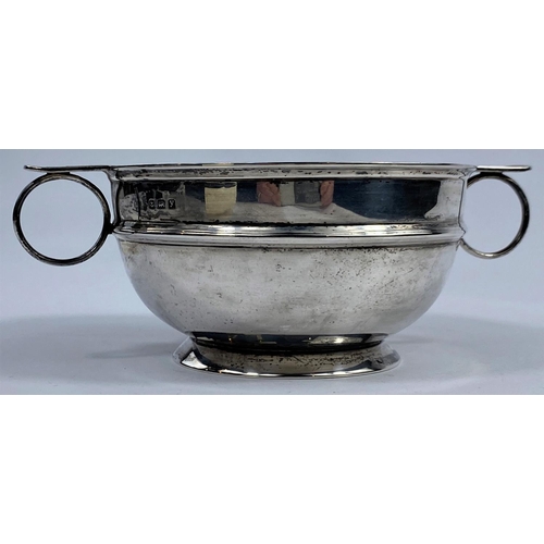 545 - A hallmarked silver circular bowl with 2 ringed handles, on raised foot, Birmingham 1923, length 17 ... 