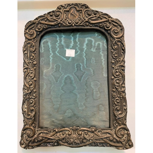 550 - An ornately embossed photo frame, Birmingham 1903, height 30 cm (worn through in parts)