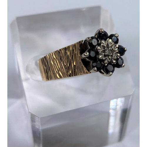 624 - A 9 carat dress ring in bark effect set central diamond surrounded by sapphire coloured stones, 52 g... 
