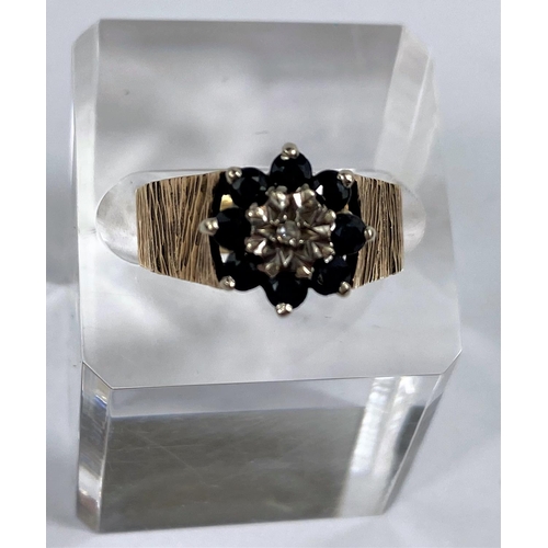 624 - A 9 carat dress ring in bark effect set central diamond surrounded by sapphire coloured stones, 52 g... 