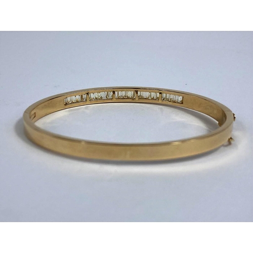 630 - A yellow metal hinged bangle, stamped 750, set with 24 baguette cut diamonds, approximate L: 2.2mm a... 