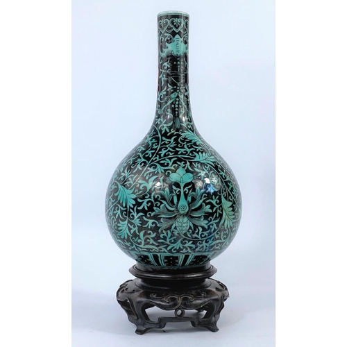 358 - A Chinese black and green glaze bottle vase with detailed plant and vine decoration, ht. 19cm with a...