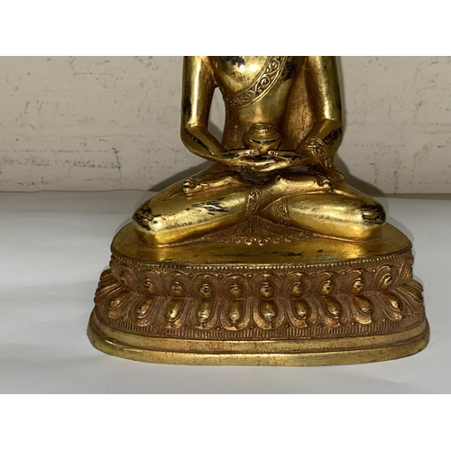 361 - A Chinese bronze gilded figure of a buddha in lotus position, ht. 23cm