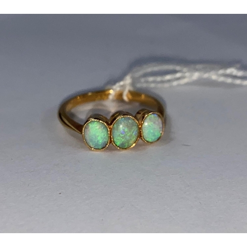 554 - A yellow metal ring set 3 opals, stamped '18ct', 2.6 gm
size M.