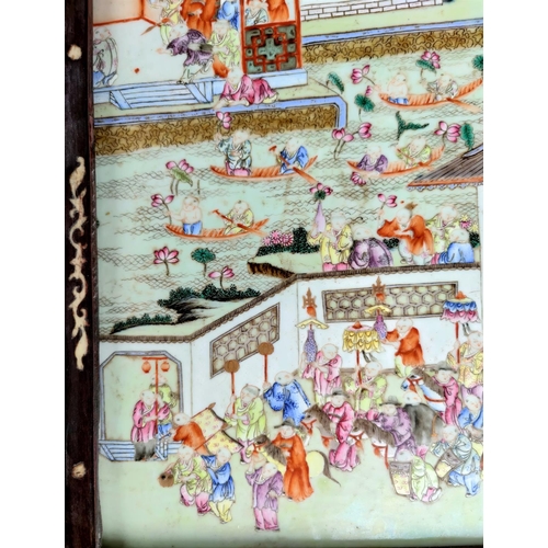 390A - A large Chinese ceramic tile with polychrome decoration of a busy festival scene with musicians, boa... 