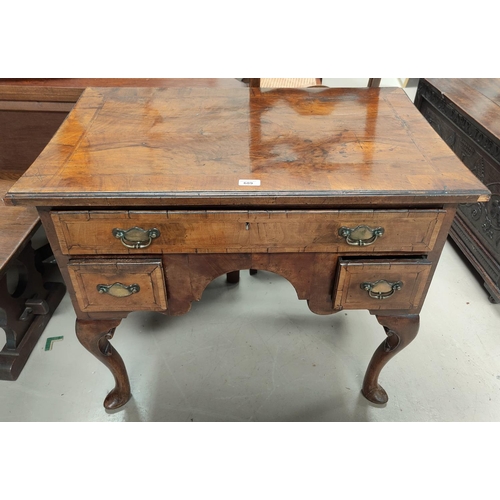 689 - A mid Georgian lowboy in quarter veneered and crossbanded walnut with herringbone inlay, 1 long and ... 