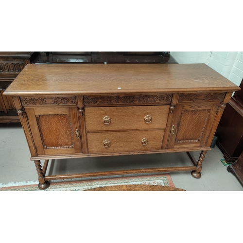 712a - A 1930's golden oak sideboard of 2 cupboards and 2 drawers, on barley twist legs