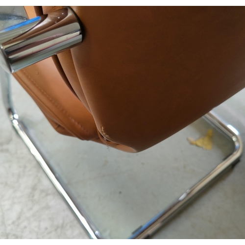 824 - A tubular chrome armchair in tan leather