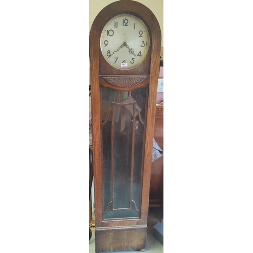 842 - A 1930's oak arch top long case clock with weight driven striking movement