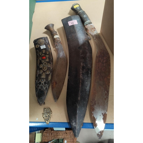 15 - A large Khukri with leather scabbard; a smaller Khukri with brass mounted scabbard