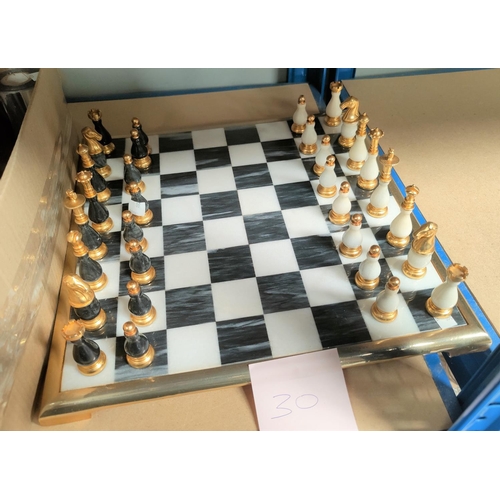 30 - A chess set in gilt metal and black marble, with board