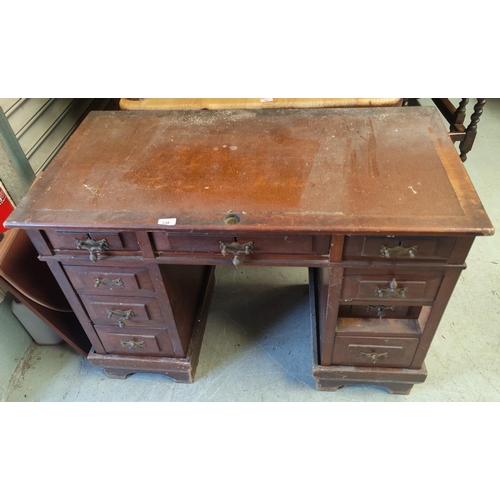 738 - An Edwardian stained mahogany kneehole desk with inset top, 3 frieze and 6 pedestal drawers