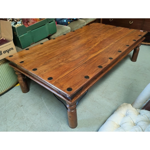 829 - A large rustic rectangular coffee table on turned legs with steel brackets