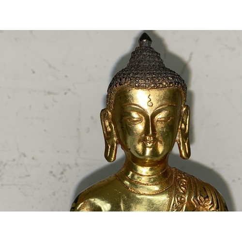 361 - A Chinese bronze gilded figure of a buddha in lotus position, ht. 23cm