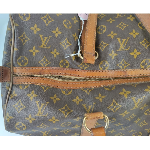 72 - A Louis Vuitton 'sacsouple'/keepall, monogrammed, with tan leather strapping and handles, zip tab em... 