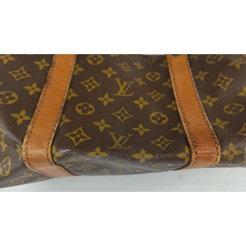 72 - A Louis Vuitton 'sacsouple'/keepall, monogrammed, with tan leather strapping and handles, zip tab em... 