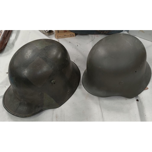 168 - A German style steel helmet with a leather lining and a similar reproduction helmet.
