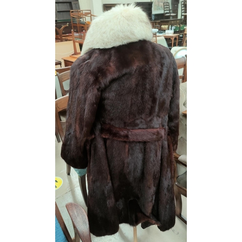 42A - A full length dark chocolate brown mink coat with belt and pale fox fur collar, size 10 / 12