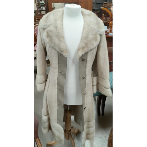 42E - A modern full length pale mink coat with beige leather trim to front, sleeves and hemline, horizonal... 