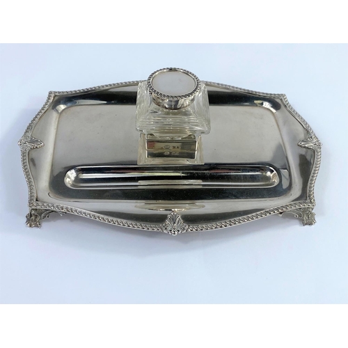 625 - A hallmarked silver inkstand in the classical style with glass bottle, on gadrooned shaped rectangul... 