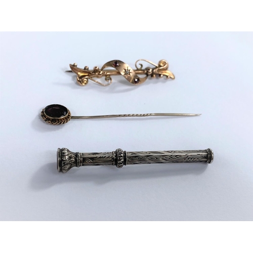 632 - An Edwardian bar brooch with entwined filigree decoration, set 2 small rubies and a diamond; a stick... 