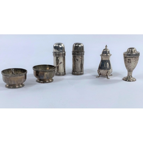 654 - A hallmarked silver pair of salts of circular ribbed form on raised pedestal feet, Birmingham 1925; ... 