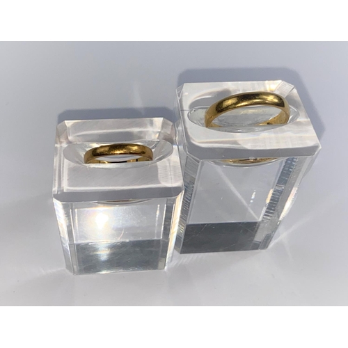 679 - A small hallmarked gold wedding ring stamped 22ct size F/G; and a 22ct hallmarked wedding ring gross... 