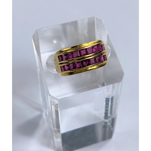 683 - A yellow metal dress ring stamped 22ct set with two rows of square cut rubies in a double split shan... 