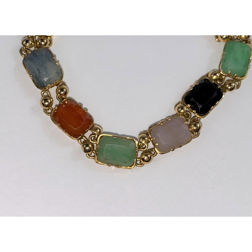 696 - A yellow metal bracelet set with multicloured stones, unmarked (tests as circa 18ct.)