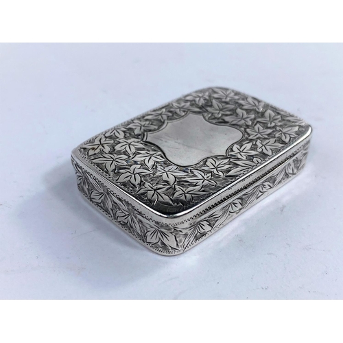 612D - A rectangular silver snuff/pill box with chased leaf decoration and shield cartouche, hinged lid, Ch... 
