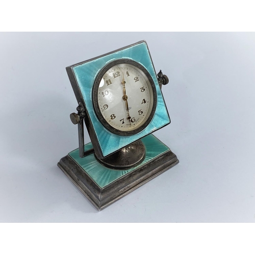 580B - An Art Deco style green enamel on silver, swivel mounted dressing table/desk clock on a rectangular ... 