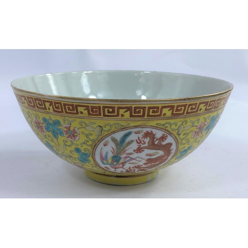 612 - A Chinese yellow glaze bowl with four detailed circular polychrome panels depicting a pheonix and a ... 