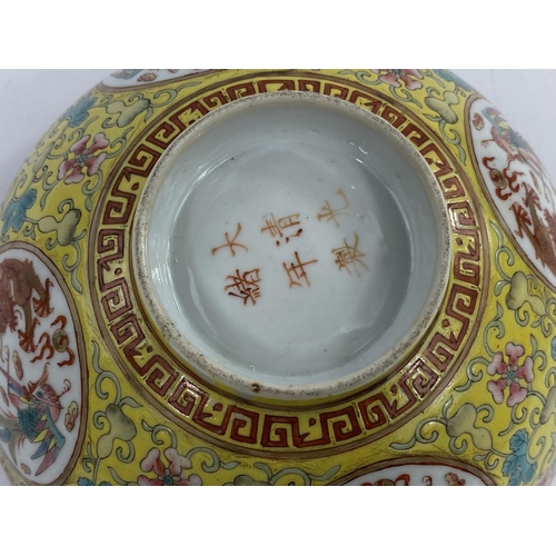 612 - A Chinese yellow glaze bowl with four detailed circular polychrome panels depicting a pheonix and a ... 