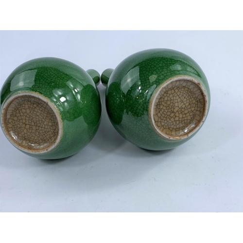 610 - A pair of Chinese monochrome green crackle glaze bottle vases, with slender necks and bulbous bodies... 