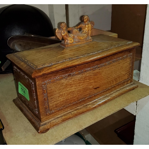 114 - An Arts and Crafts box of bombe form, oak 20th century, with finial of 2 angels, 22cm