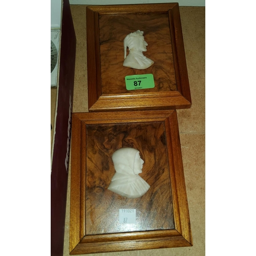 87 - A relief carved pair of head and shoulder silhouettes on walnut plaques
