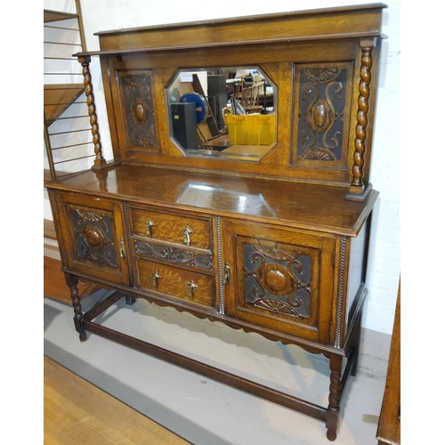 520A - A 1920's oak mirror back sideboard with two carved doors and drawers below with canted rectangular m... 