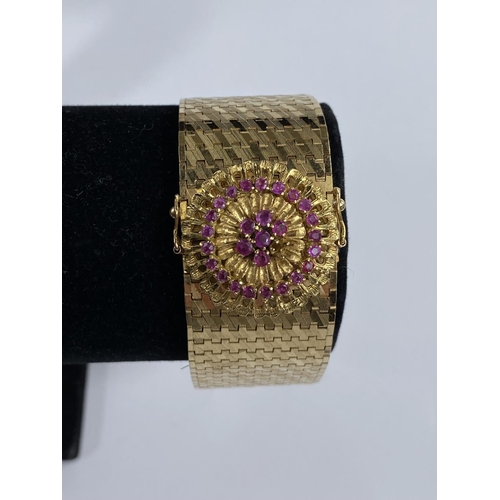 719 - A Continental gold strap bracelet with rose clasp set small rubies, stamped 750, 80.6gm, length 19.5... 