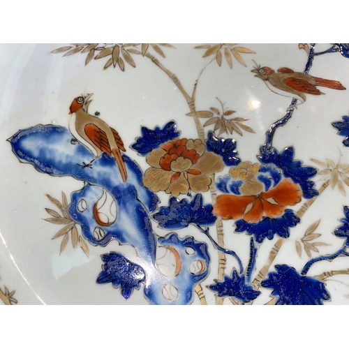 614B - A large Chinese porcelain charger with central panel depicting birds on trees with gilt highlight, d... 
