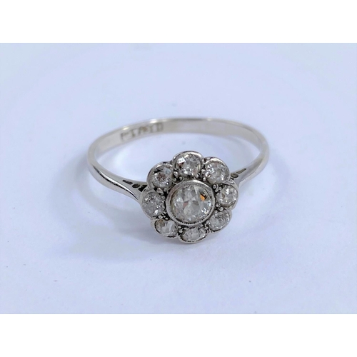 691D - An 18 carat white gold dress ring with central diamond surrounded by 8 smaller diamonds in flowerhea... 