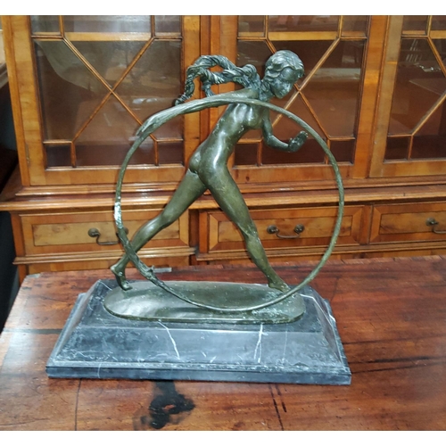 740a - An Art Deco style bronze group of a naked girl with large hoop, on grey marble plinth, height 44cm