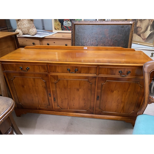 905B - A reproduction yew wood sideboard with three drawers and three cupboards below