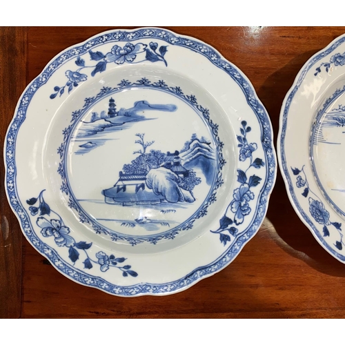 612C - A pair of 18th century Chinese blue and white shallow dishes with traditional mountain scenes, scall... 