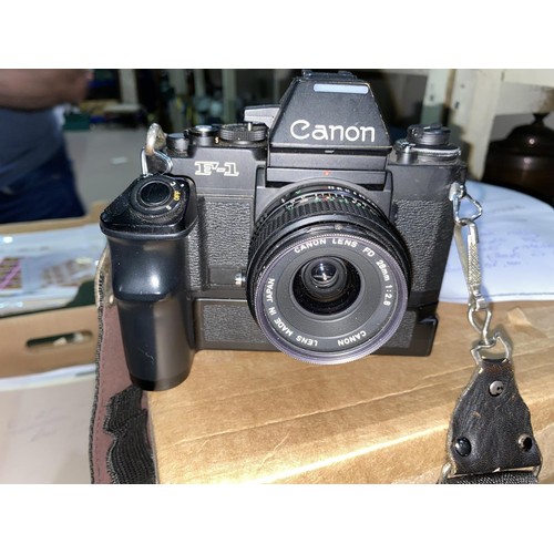 134 - A Canon F-1 SLR camera 206979 with various 
accessories and lenses, a FD 28m 1:2.8, a cannon Zoom le... 