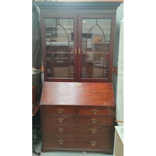 830 - A Georgian bureau bookcase with glazed double doors to the top with arched decoration, four drawers ... 