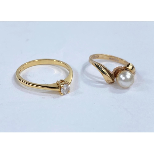 597A - An 18 carat gold diamond set solitaire dress ring, 2.5gm; a 9 carat pearl set crossover ring, 1.8gm