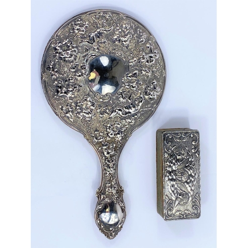 649 - A hallmarked silver hand mirror with heavily embossed decoration of cherubs and fruiting vines, Birm... 