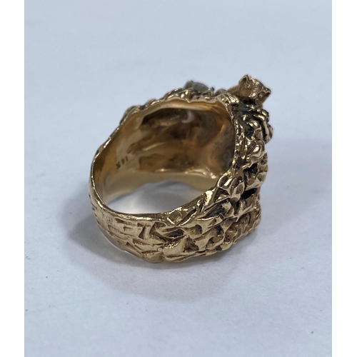 651D - A yellow metal dress ring in the form of a mountain cat climbing rocks, stamped 14k with two diamond... 