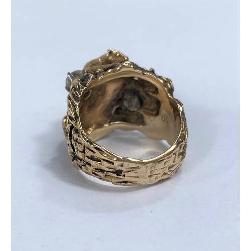 651D - A yellow metal dress ring in the form of a mountain cat climbing rocks, stamped 14k with two diamond... 